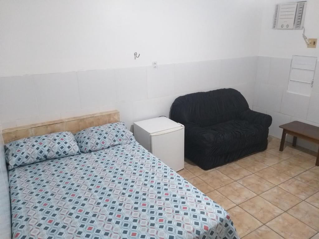 1 dormitorio con 1 cama y 1 silla en Hotel Primu's en Novo Airão