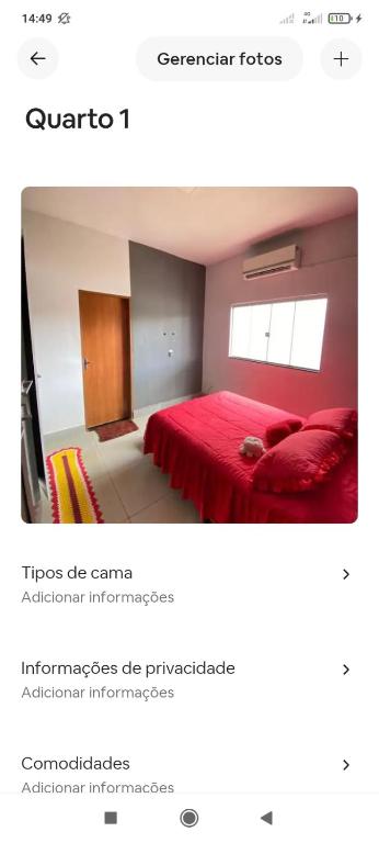 a bedroom with a red bed and a window at Casa de temporada in Trindade