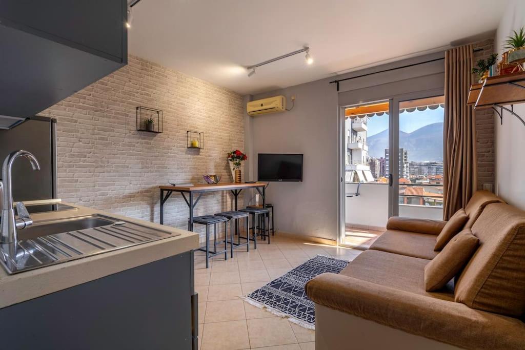 a kitchen and living room with a couch and a table at NEW BAZAAR Apartment in Tirana