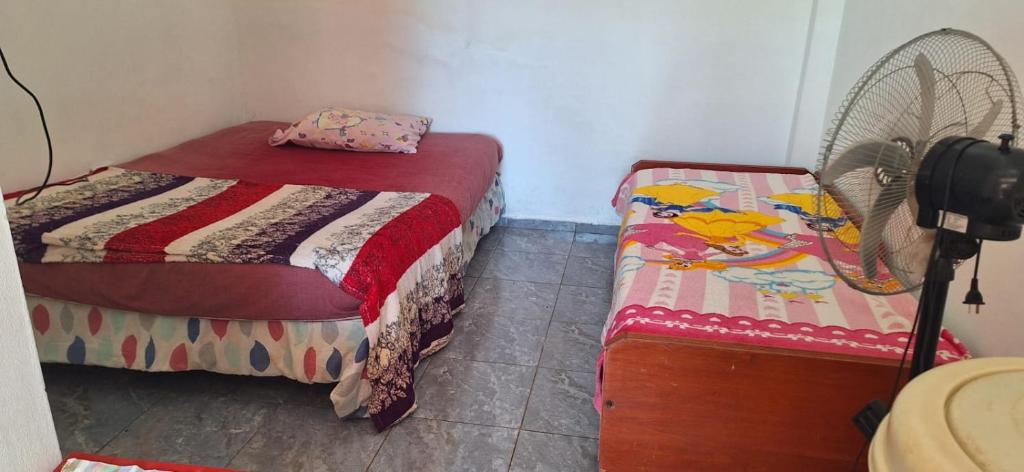 sypialnia z 2 łóżkami pojedynczymi i wentylatorem w obiekcie Alojamientos juaky w mieście Garupá