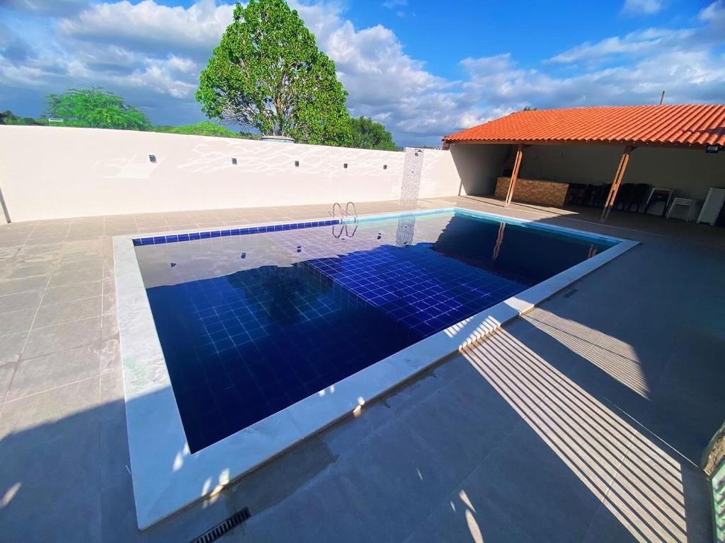 uma piscina com azulejos azuis em cima de uma casa em Chácara com uma área de lazer top em Caruaru