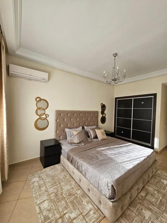 - une chambre avec un grand lit et un lustre dans l'établissement appartement familiale tanger R, à Tanger