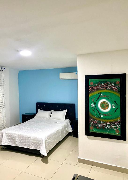 a bedroom with a bed with a painting on the wall at Hotel Estefanía Princess 84 in Barranquilla