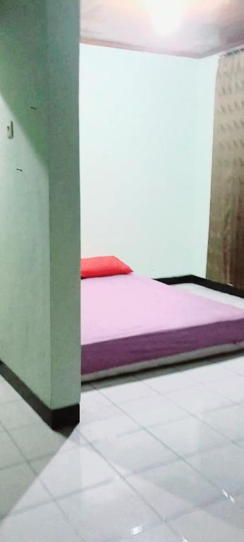 een slaapkamer met een bed in een kamer bij HOMESTAY SYARIAH ENDRA JATI in Tjepit