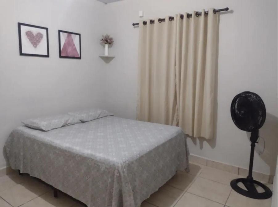 a bedroom with a bed and a fan in it at Casa em Uberaba com garagem in Uberaba