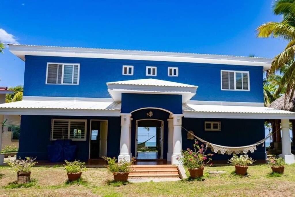 ein blaues Haus mit Palmen davor in der Unterkunft Welcome to The Beach House in Playa Pochomil