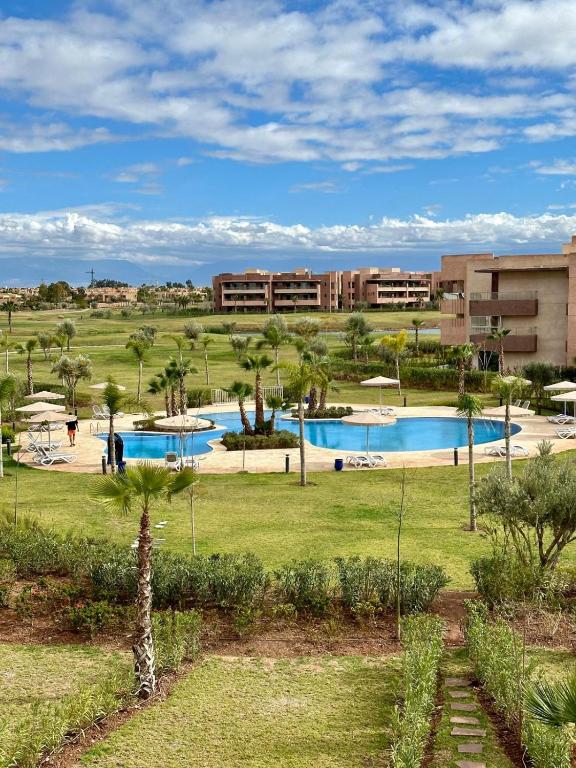 un complexe avec 2 piscines et des palmiers dans l'établissement Appartement Prestigia 3 chambres, à Marrakech