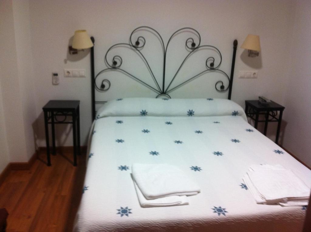 a bedroom with a bed with blue flowers on it at Hotel Mesón del Moro in Abarán