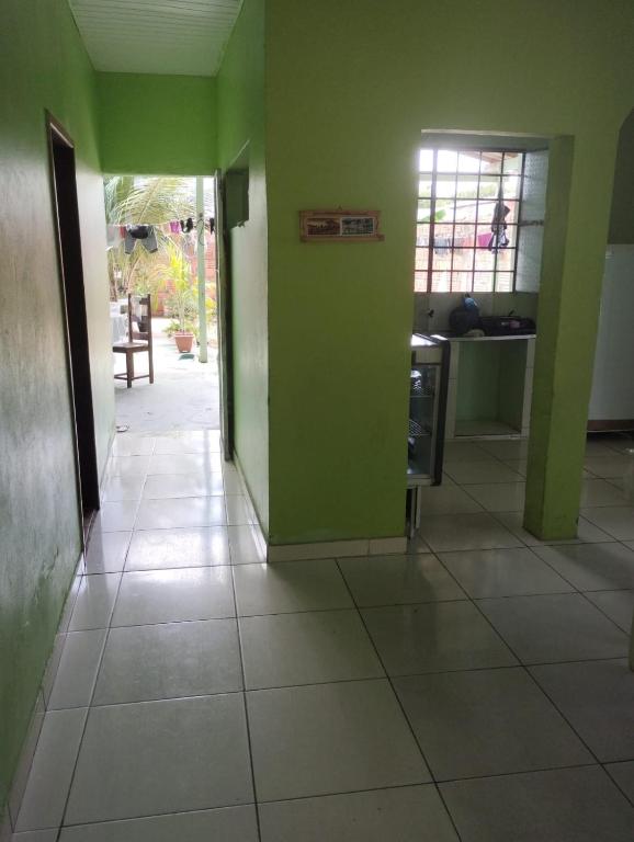 an empty hallway with green walls and a kitchen at Casa em Parintins in Parintins
