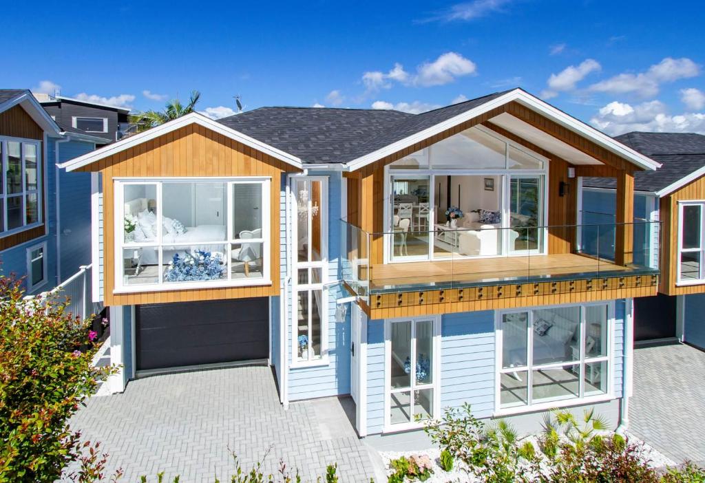 a house with a lot of windows at Stunning Rothesay Bay in Auckland