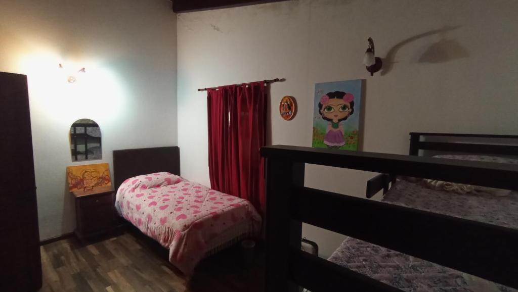 1 dormitorio con litera y cortina roja en Casa en los Nogales Yala in 