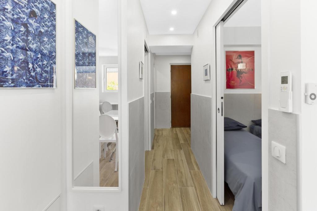 a small room with a bed and a hallway at Cannes NG - Appartement à 10 mn du Palais des Festivals in Cannes