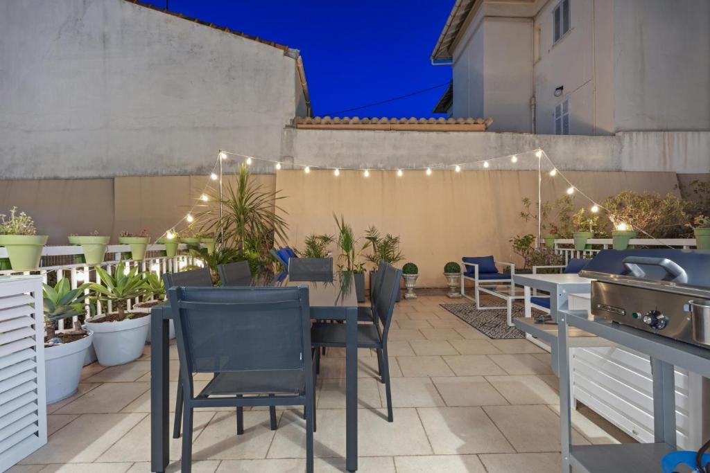 a patio with a table and chairs and plants at Cannes NG - Appartement à 10 mn du Palais des Festivals in Cannes