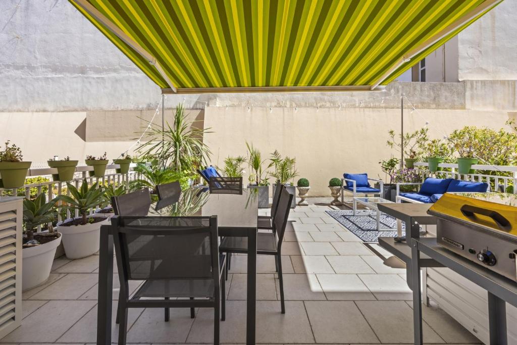a patio with a table and chairs and plants at Cannes NG - Appartement à 10 mn du Palais des Festivals in Cannes