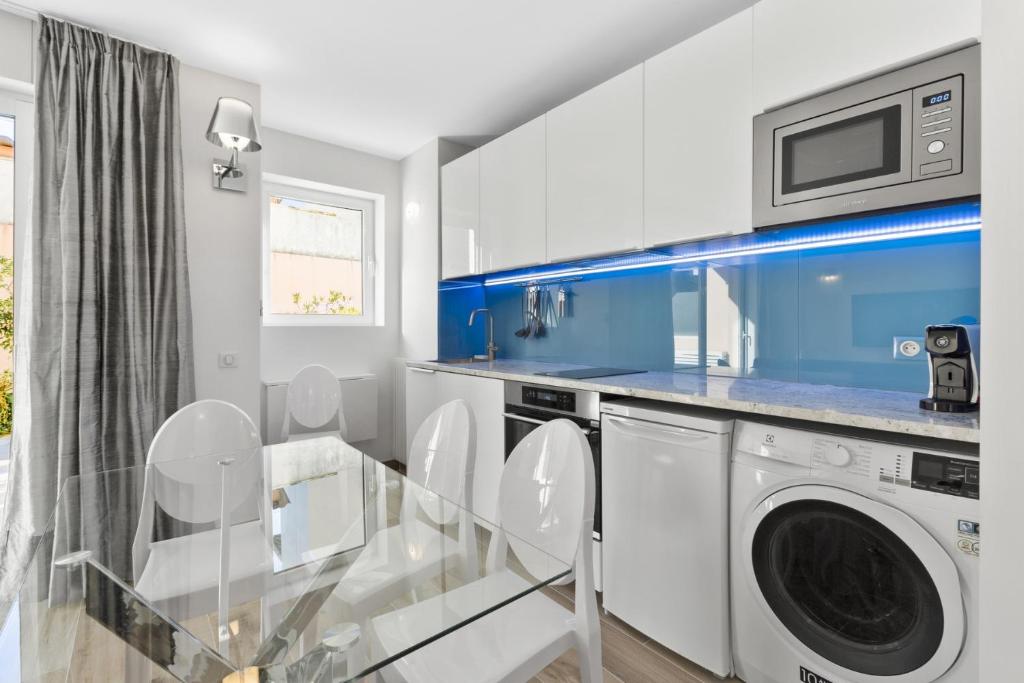 a white laundry room with a washer and dryer at Cannes NG - Appartement à 10 mn du Palais des Festivals in Cannes