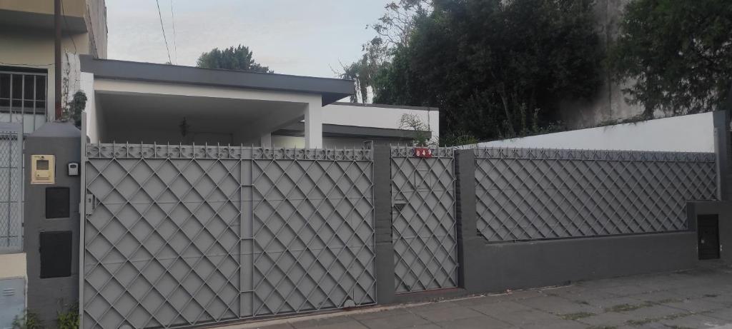 una recinzione di legno di fronte a una casa di casa con garaje rejas y camaras a 24 minutos del aeropuerto Ezeiza Amplio parque para mascotas a Ezeiza