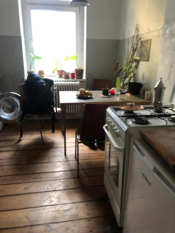 eine Küche mit einem Herd und einem Tisch mit einem Esszimmer in der Unterkunft Cuddle Nest in Berlin