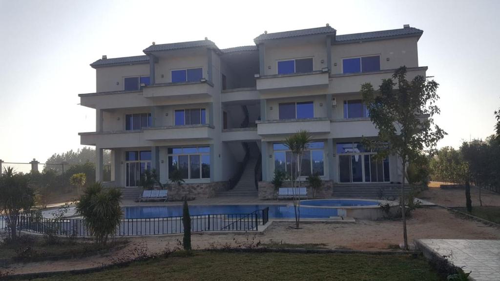 ein Gebäude mit einem Pool davor in der Unterkunft فندق الفخامة in El-Qaṭṭa
