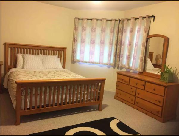 een slaapkamer met een bed, een dressoir en een spiegel bij Private 1 bedroom 1 bath with separate entrance in a house in Burnaby