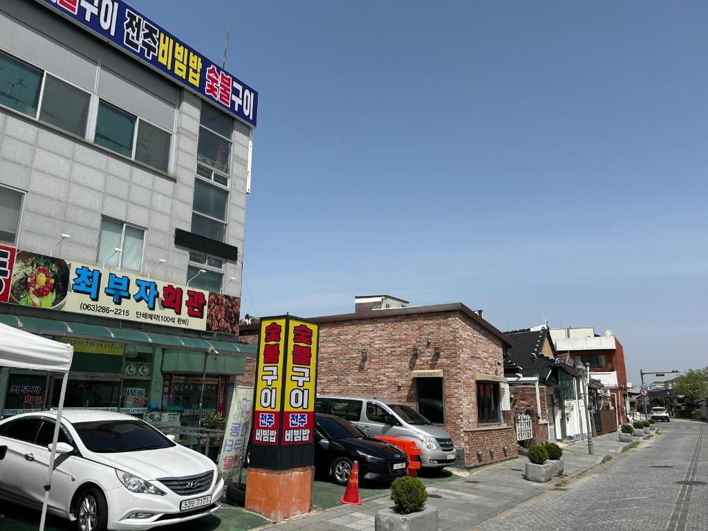 a street with cars parked in front of a building at Maru 1000 years in Jeonju