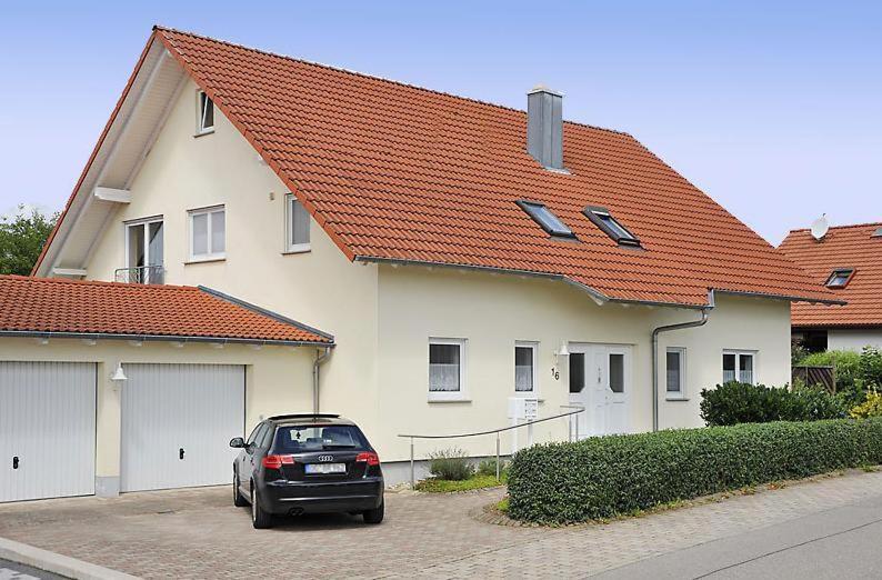 une voiture garée dans un parking en face d'une maison dans l'établissement Gästehaus-Après-Park, à Rust