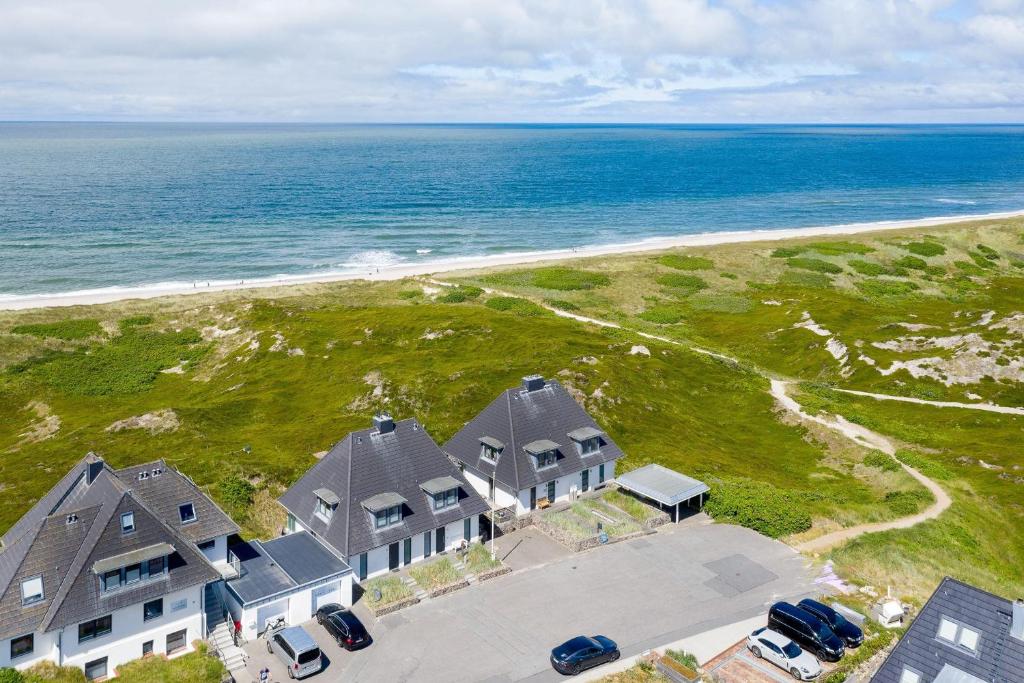 an aerial view of a house and the ocean at Lands-End in Hörnum