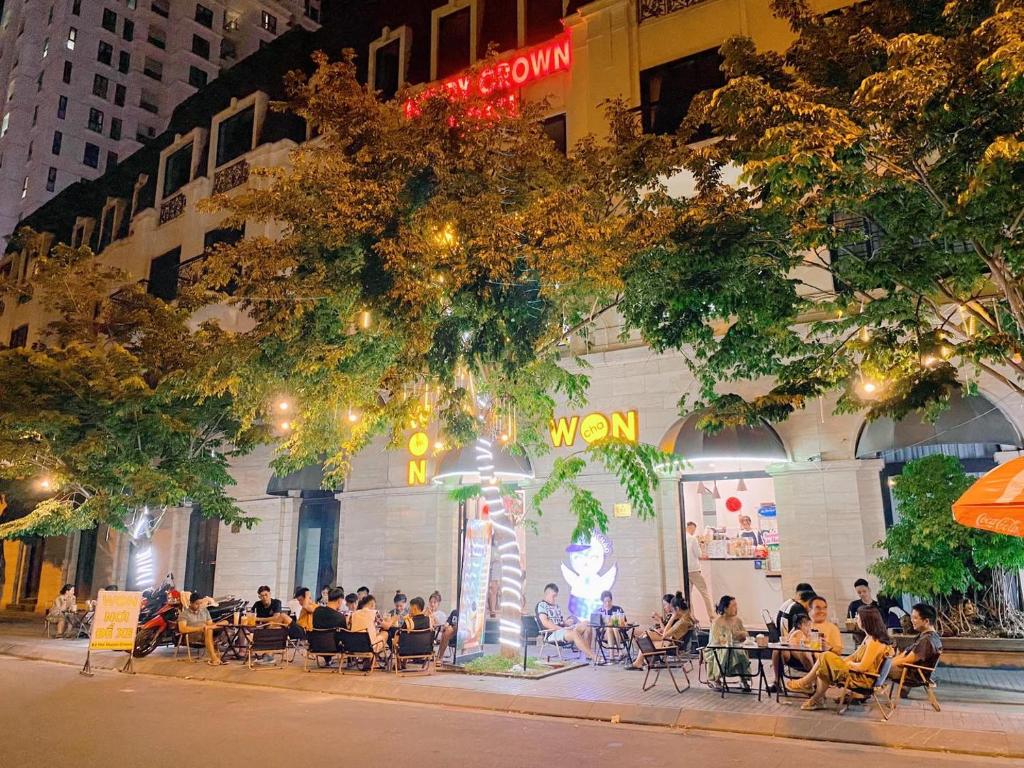 a group of people sitting at tables outside of a building at Henry Crown Hotel in Thôn Trường Giang