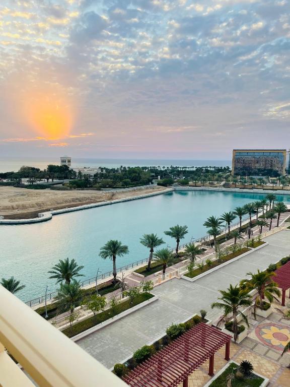 a view of a large swimming pool with palm trees at شقة البيلسان فيو Baylasun View in King Abdullah Economic City