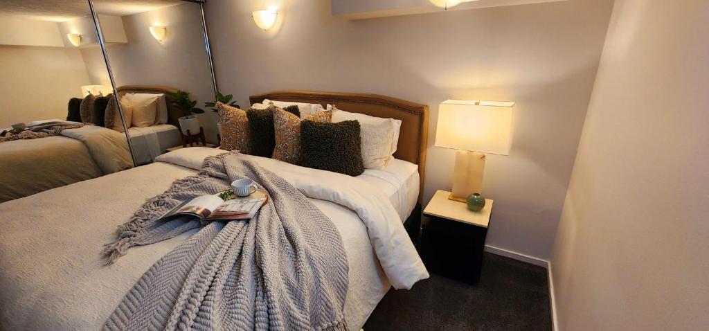 a bedroom with a bed with a blanket and a lamp at NYC Loft Brisbane, Free Parking! in Brisbane