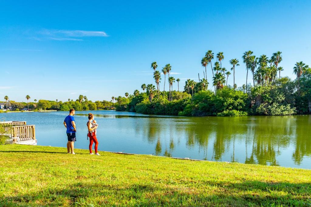 a man and a woman standing in front of a lake at Waterfront Oasis with Bunk Room by SpaceX and SPI in Brownsville