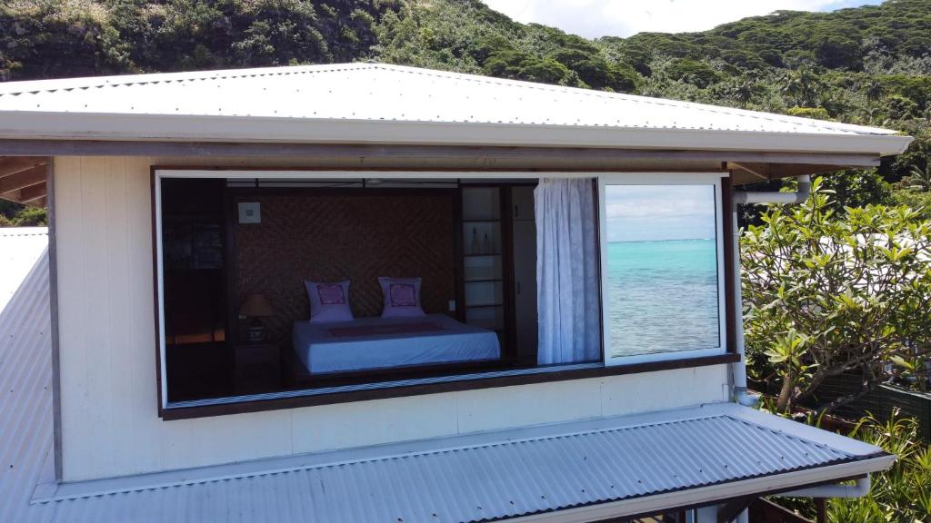 - une chambre dotée d'une fenêtre offrant une vue sur l'océan dans l'établissement Maison d’hôtes bord de mer ia orana lodge, à Moorea