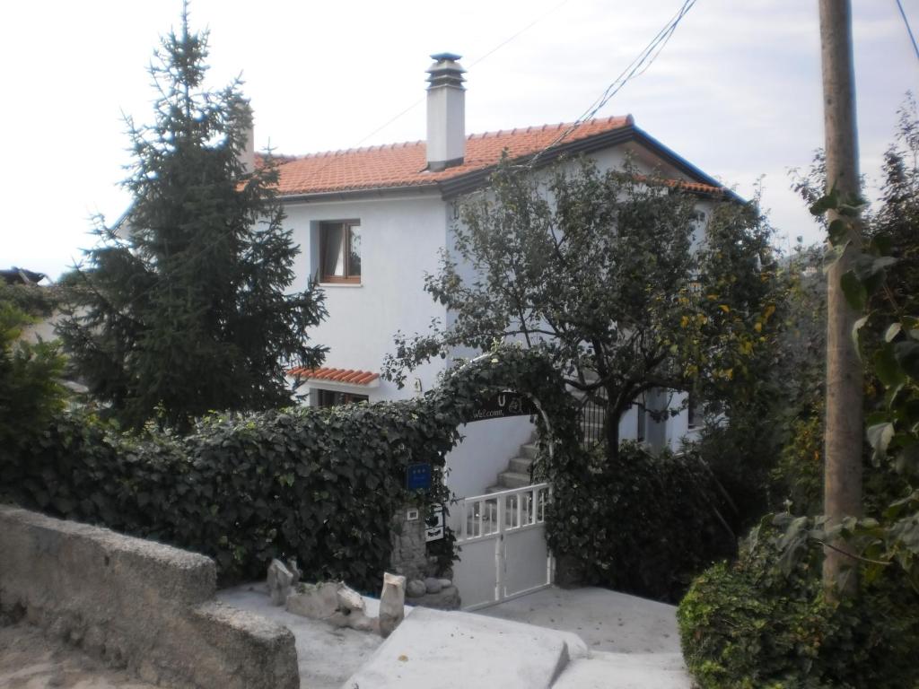 a white house with a gate and a fence at Apartment Haldej in Mošćenička Draga