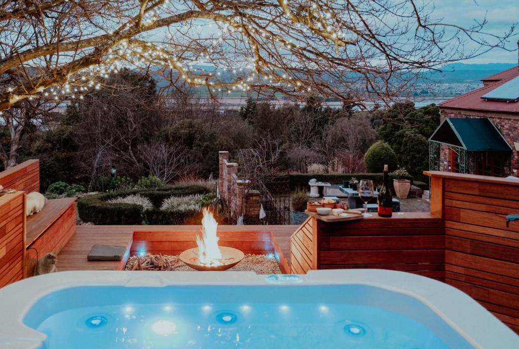 a hot tub in a backyard with a fire pit at Outdoor Spa & Sauna with amazing views at Jaclyn Studio in Launceston