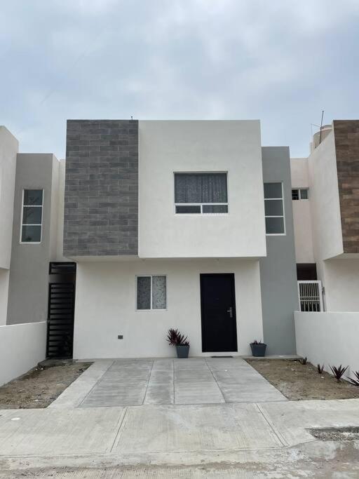 a large white building with a black door at Casa santeli miramar in Ciudad Madero