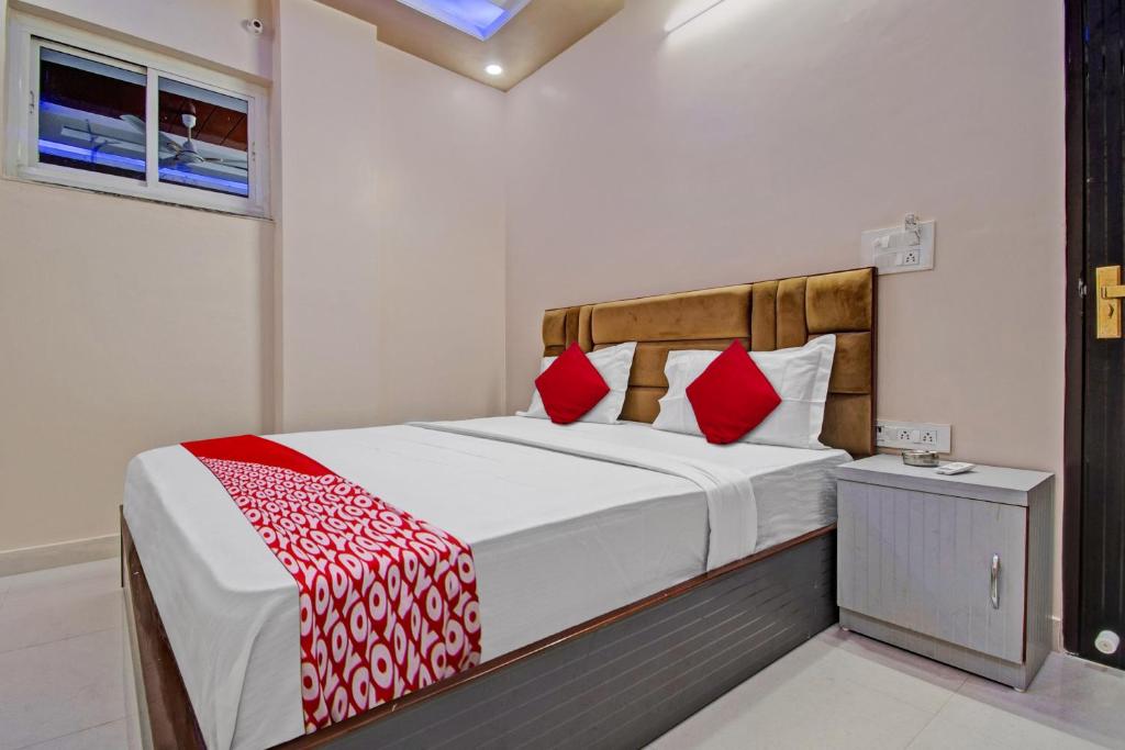a bedroom with a large bed with red pillows at Hotel Krishna Palace in Jaipur