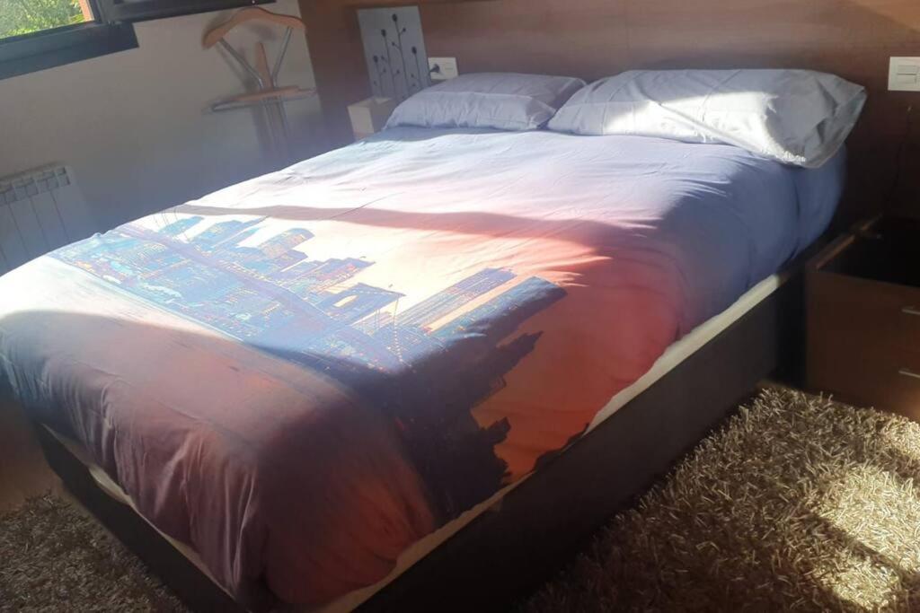 Una cama con un edredón con una sombra. en Chalet en Asturias, en Gijón