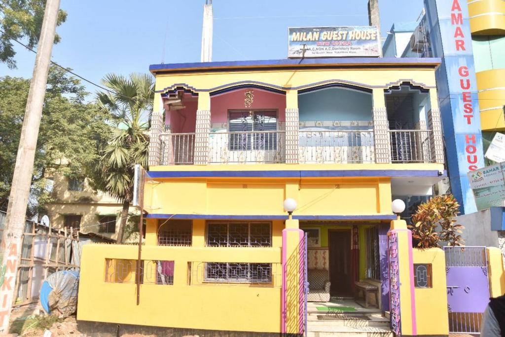 a yellow building with a balcony on a street at Hotel Milan Guest House Digha - Couple Friendly in Digha