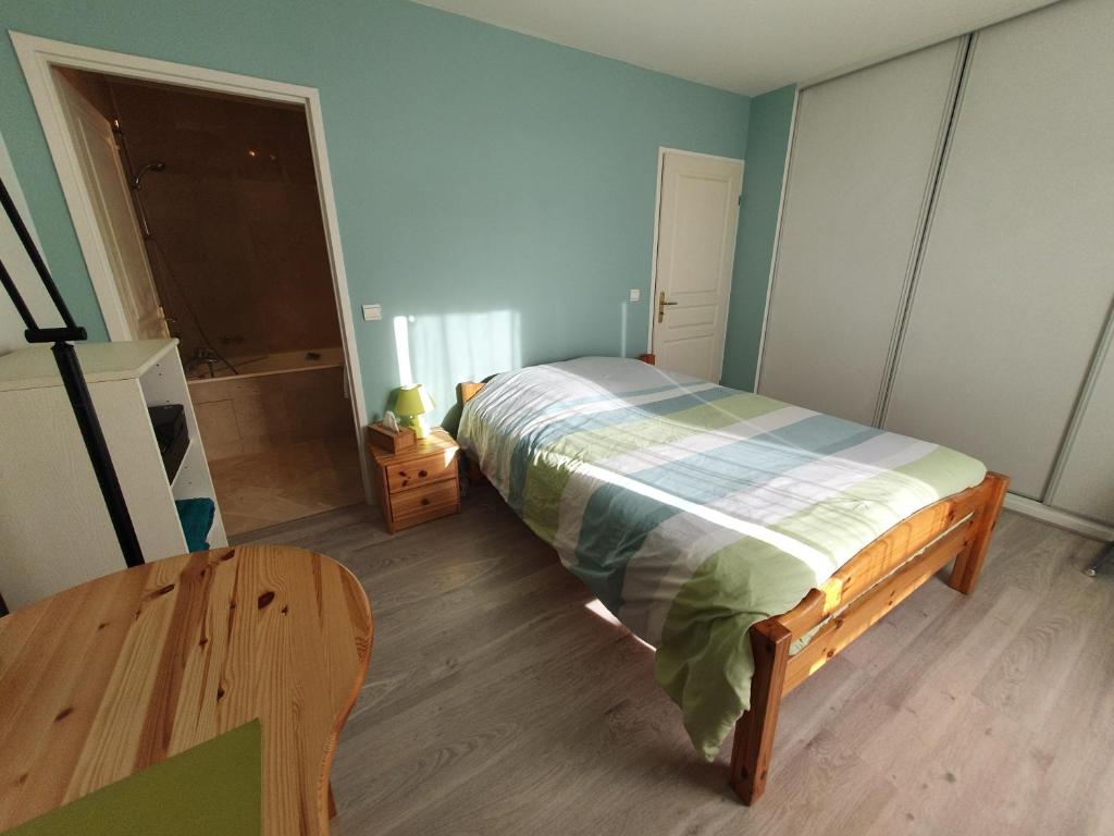 - une chambre avec un lit et une table en bois dans l'établissement Calm appartment with its terrace, à Levallois-Perret