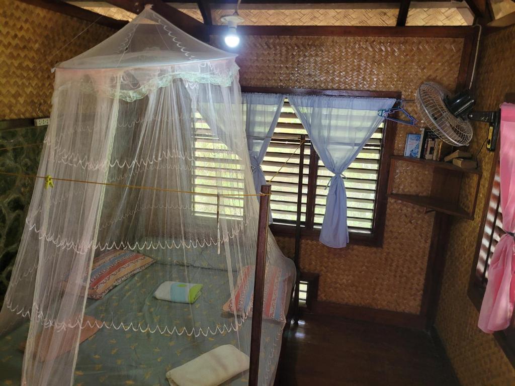 a bedroom with a bed with a mosquito net at MALAIKA RESORT in San Vicente