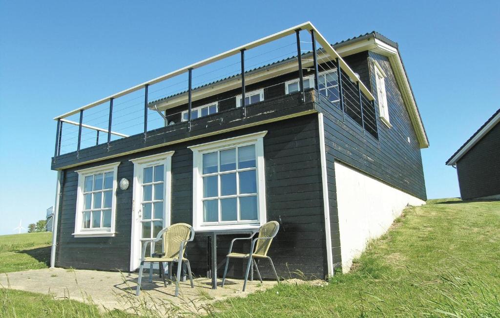a house with two chairs and a table in front of it at Holiday Home Strandgårdsvej Denm in Bagenkop