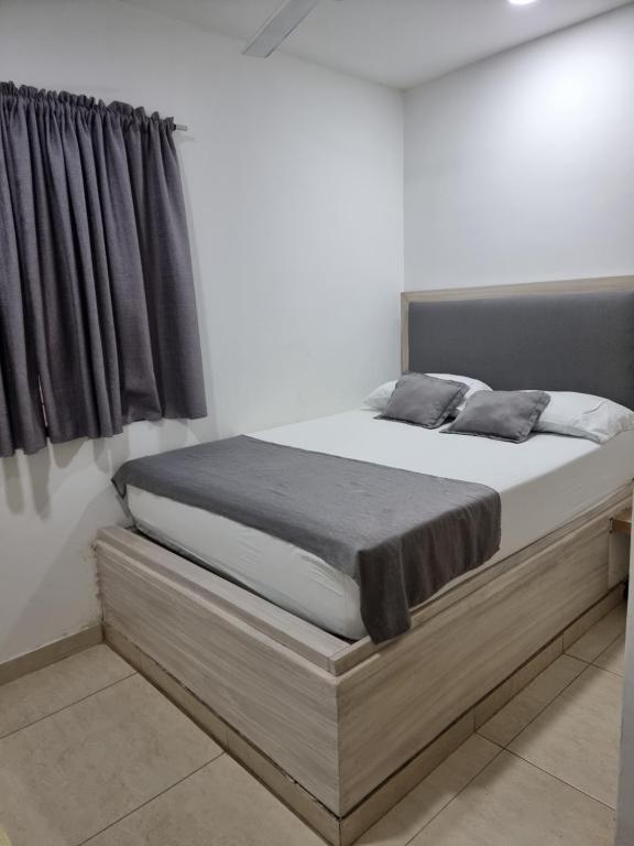 a bed in a white room with at Hotel Miami center in Montería