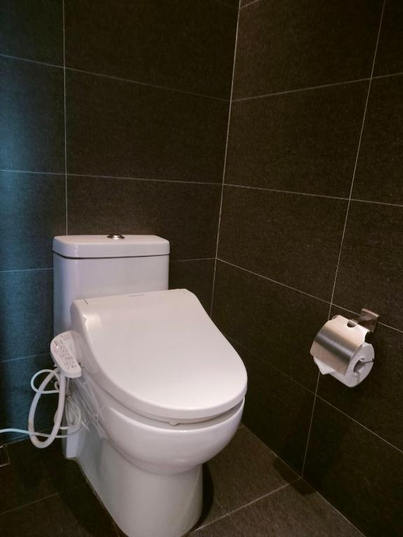 a bathroom with a toilet and a roll of toilet paper at Beitou Hot Spring Resort in Taipei