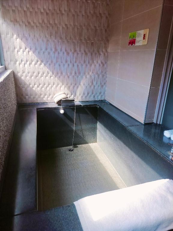 a bathroom with a counter with a sink in it at Beitou Hot Spring Resort in Taipei