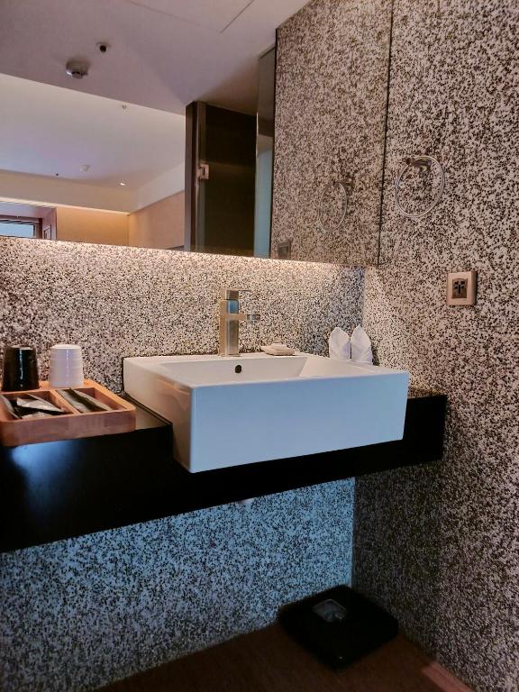 a bathroom with a white sink and a mirror at Beitou Hot Spring Resort in Taipei
