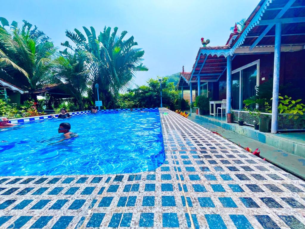 a person in the water in a swimming pool at The Four Season Hotel & Cottage, Goa in Candolim