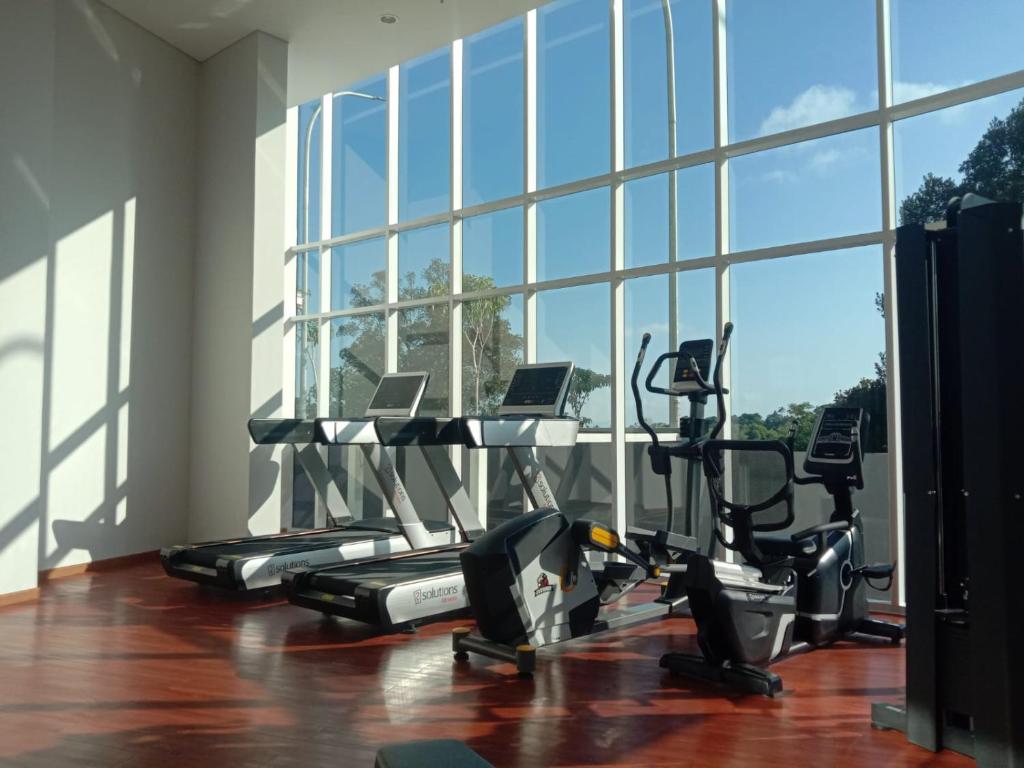 a gym with several tread machines and a large window at Sea View Family Room at Nuvasa Bay Resort in Nongsa