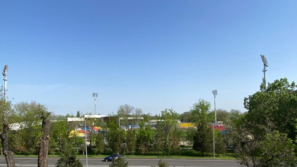 a parking lot with a park with trees and a car at 2х комнатная квартира на Толе би in Taraz