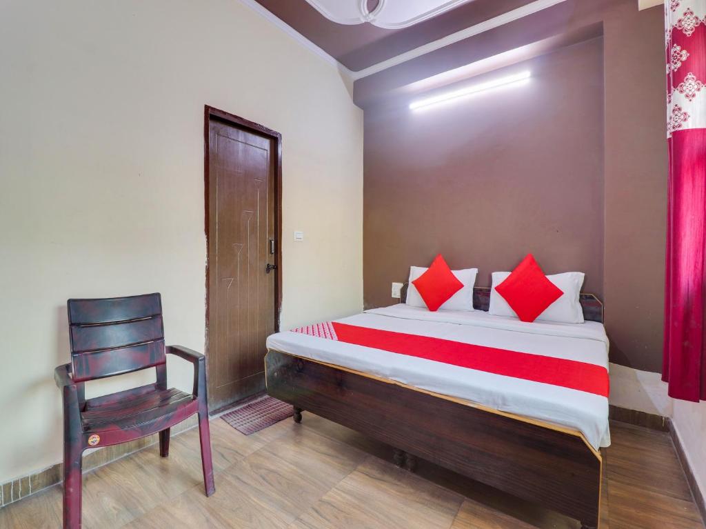 a bedroom with a large bed and a chair at OYO Hotel Kesariya Bhawan Home Stay in Dehradun