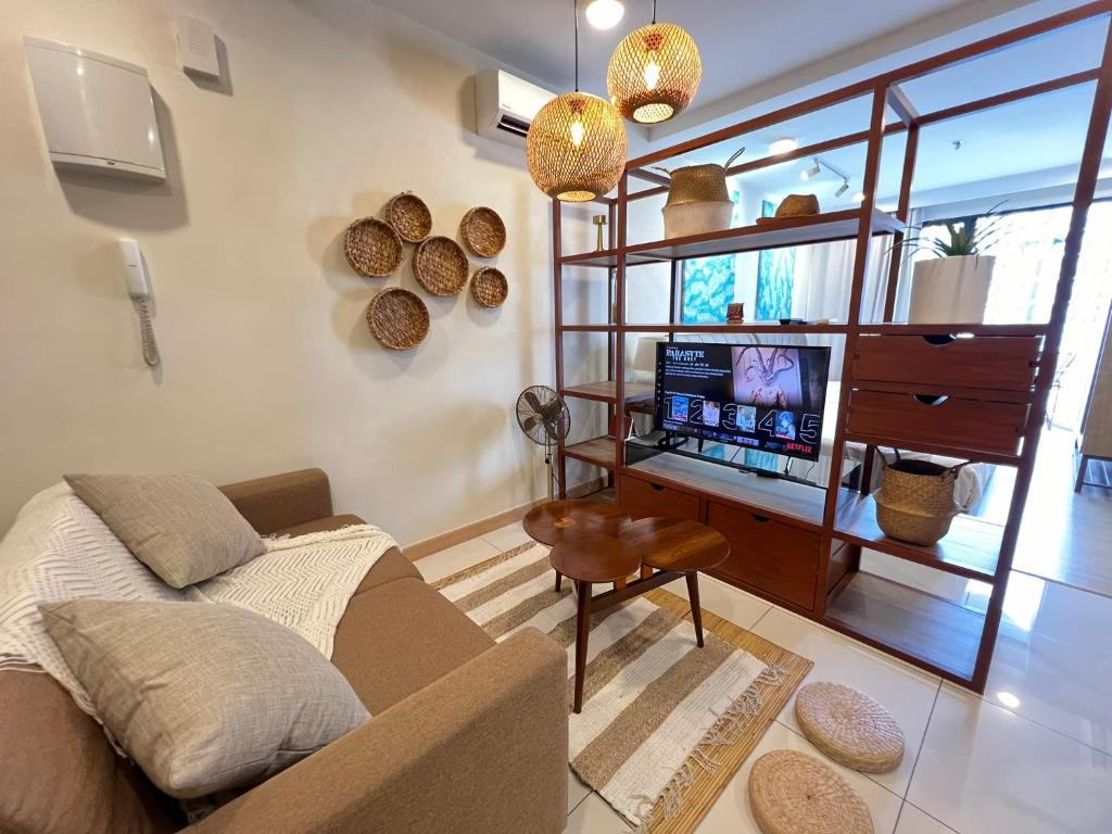 uma sala de estar com um sofá e uma secretária com uma televisão em VitaminSEA3 Seaview 6PAX Studio Netflix A-8-13A em Kuantan