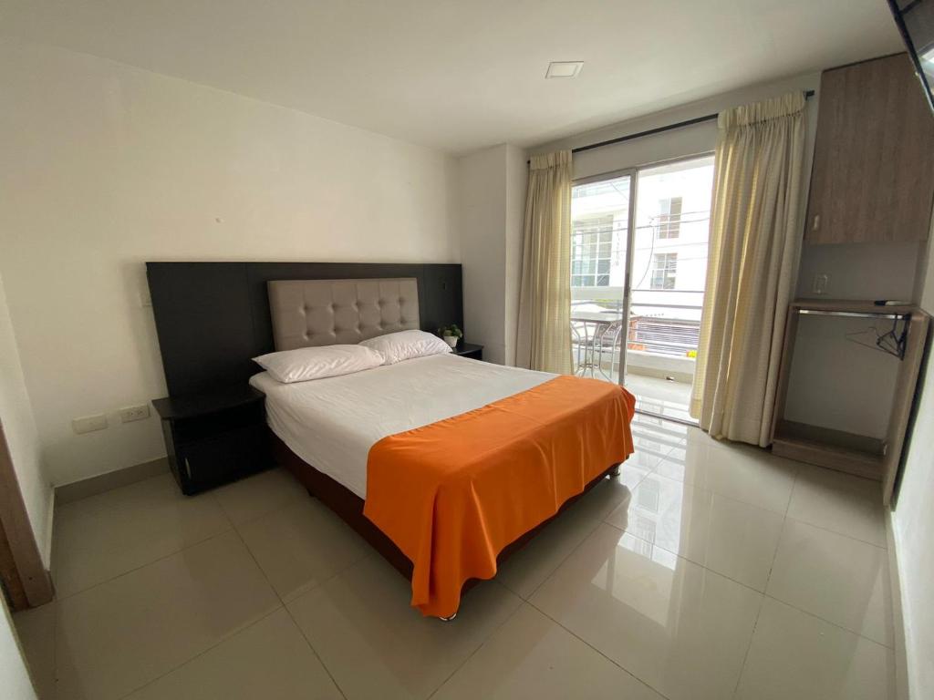 a bedroom with a bed with an orange blanket on it at Emporium Medellín Laureles in Medellín